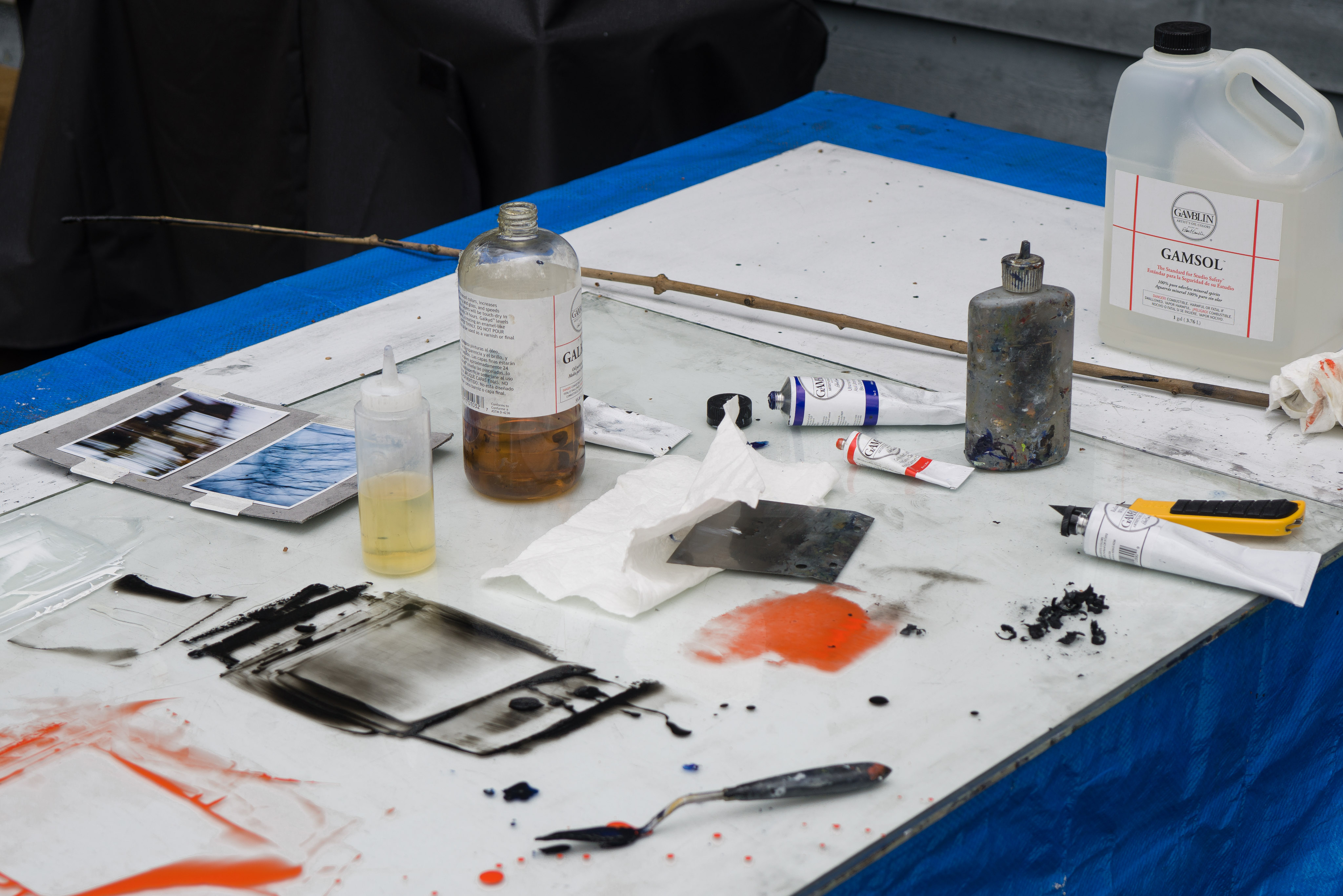 Tools and materials with work in progress, including charcoal shavings and a drawing stick cut in the forest.